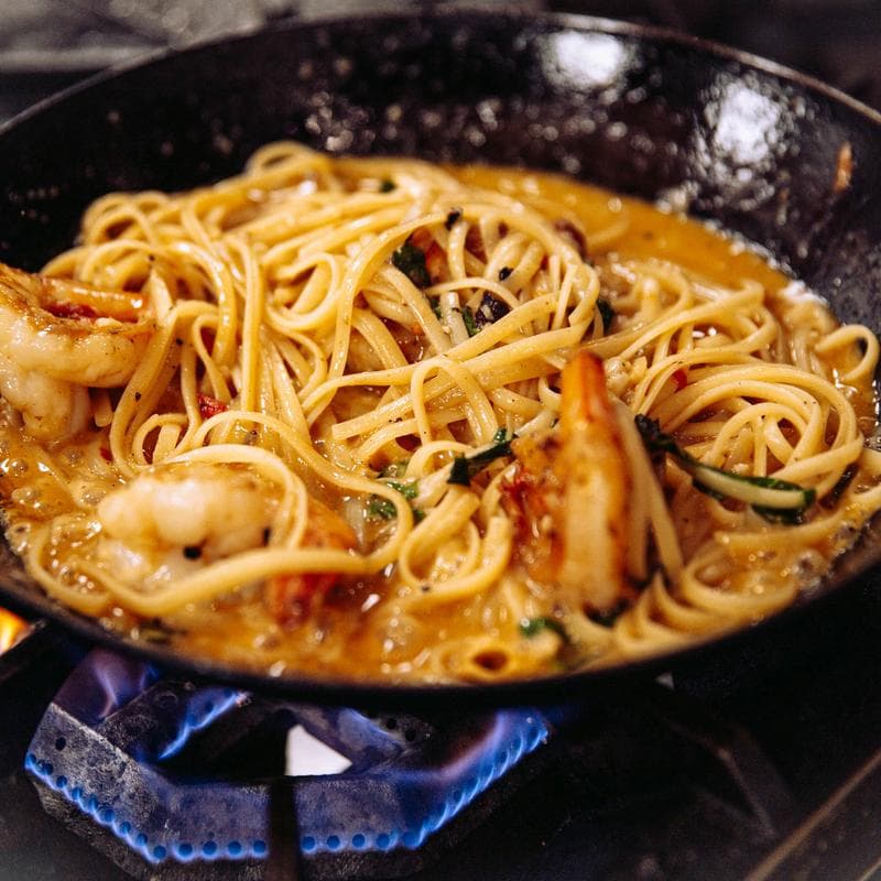 Shrimp and linguine cooking in a pan at DiMaggio's