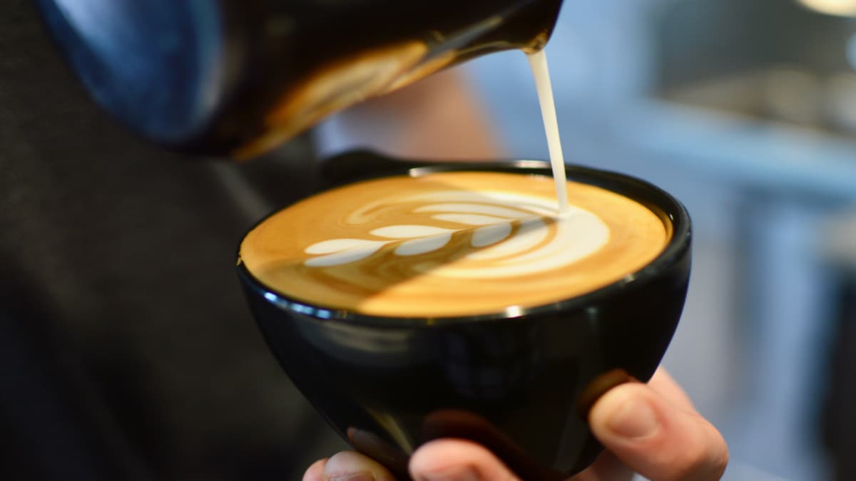 Milk being poured into a PRESS Coffee latte