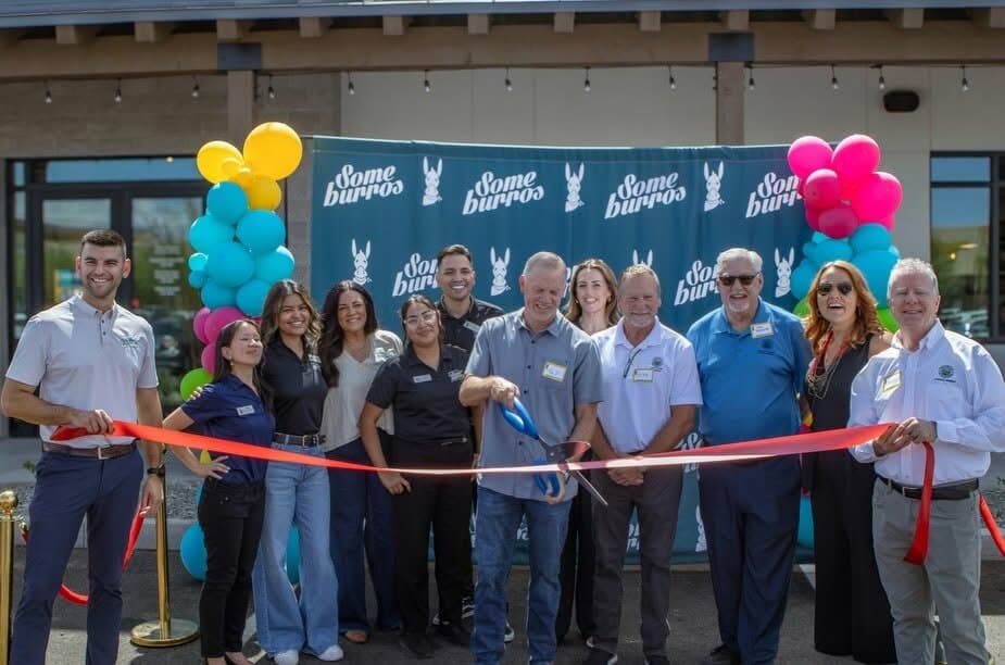 A group cutting a ribbon outside Someburros