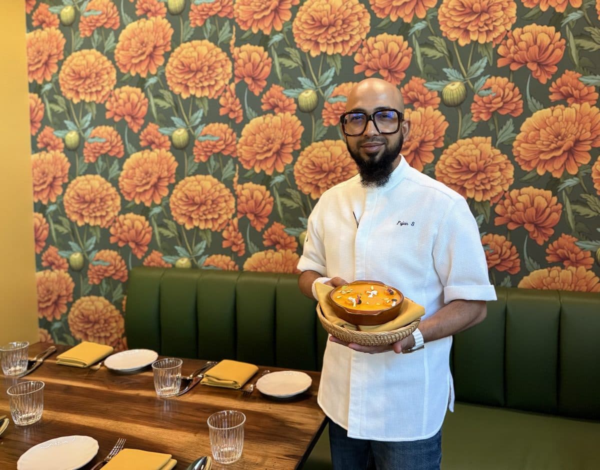 A chef holding a dish inside Nadu