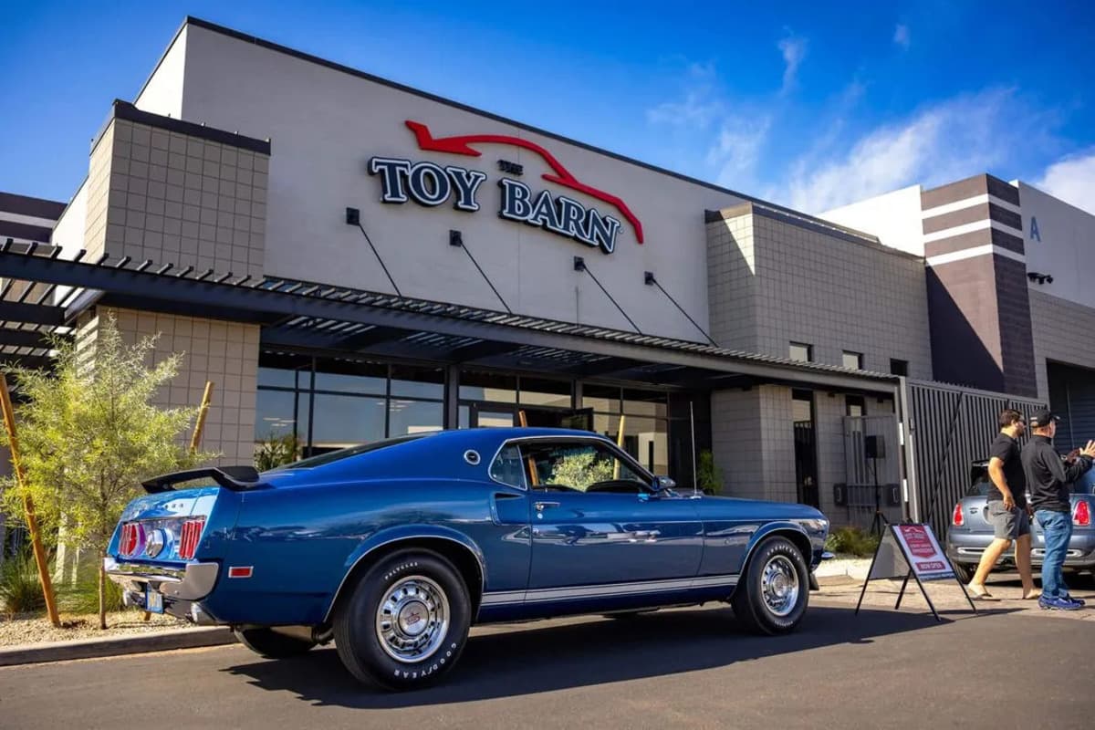 A classic car outside a Toy Barn building