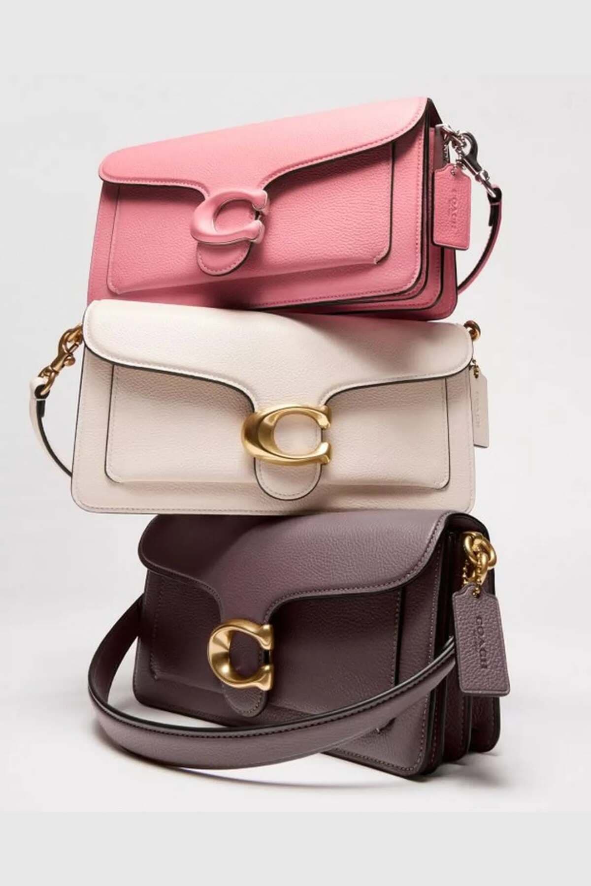 Three Coach handbags stacked together