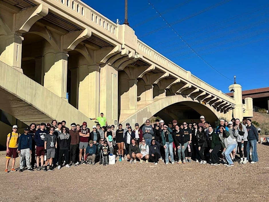 A group of volunteers beside a bridge